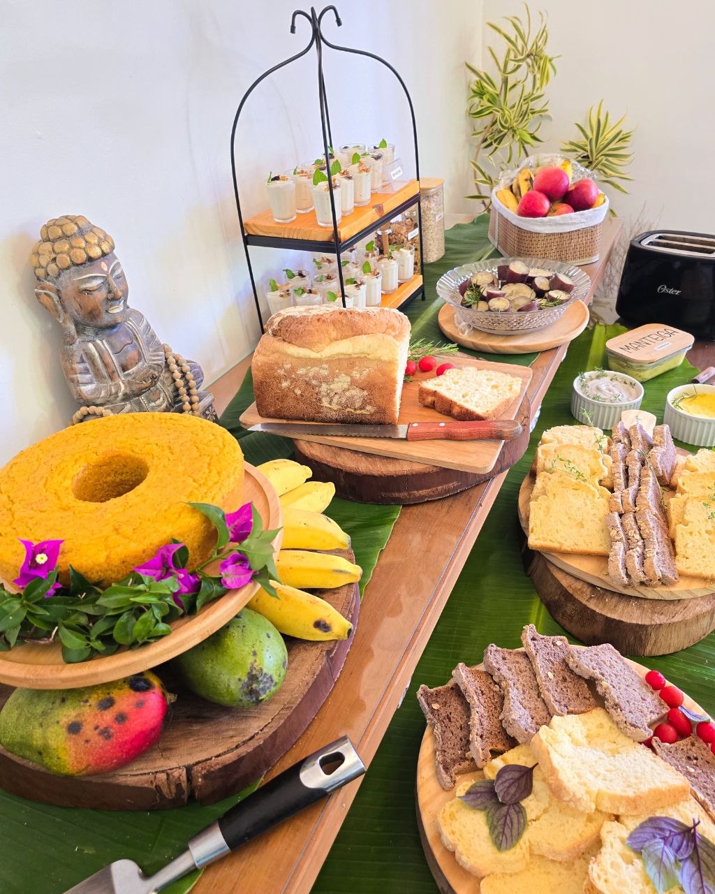 Mesa de café da manhã com bolos, pães e frutas